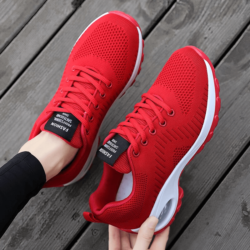 Pair of stylish red breathable women's sneakers with mesh upper and EVA insole, perfect for sports and outdoor activities.